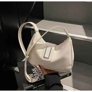 Détail d'un sac à bandoulière blanc crème à texture litchi avec boucle argentée en U