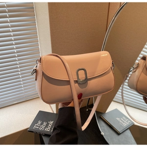Detailed mirror reflection of soft pink glossy leather crossbody bag with oval buckle