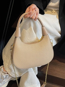 Beigefarbene gewebte Tasche mit Lederbesatz und Goldkette, getragen von einem Modell