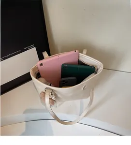 Spacious interior of a cream tote bag showing storage capacity for tablets and accessories