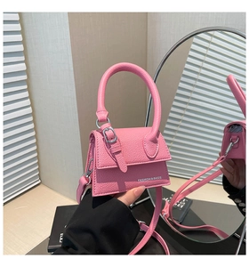 Détail du mini sac à main rose en cuir grainé avec une poignée et une bandoulière fine