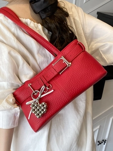Red pebbled leather underarm shoulder bag with silver buckle and heart charm details