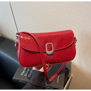 Close-up of a red vintage crackle leather handbag with a silver oval metal buckle clasp