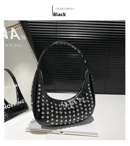 Detailaufnahme der schwarzen Halbmondtasche mit silbernen Nieten und Punk-Rock-Stil Akzenten