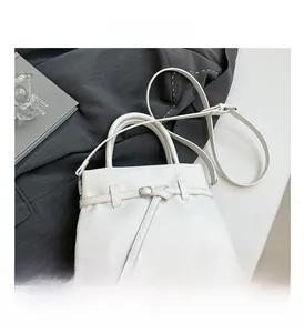 Detail of white litchi pattern leather on a small square handbag with double handles