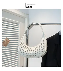 Detail der weißen Punk-Eimertasche mit silbernen Rundnieten und integriertem Schultergurt