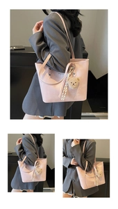 Detail view of pink leather tote bag featuring a plush bear charm and woven rope decoration