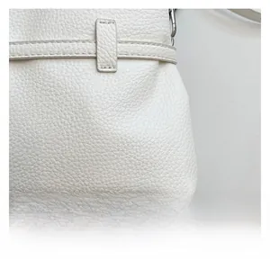 Close-up of white lychee pattern leather bag showing fine stitching and silver hardware