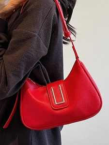 Sac à bandoulière rouge avec motif litchi et boucle en métal sur un modèle