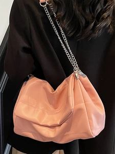 Coral pink quilted hobo bag with silver chain strap and minimalist aesthetic design