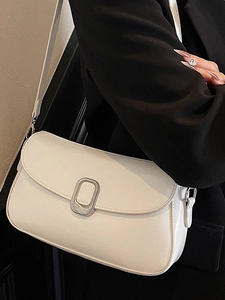 Minimalist white leather crossbody bag with silver buckle worn on a black blazer jacket