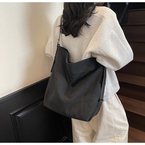 Detailed view of black oversized canvas tote bag showing large capacity and adjustable strap