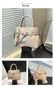 Detail view of khaki pebbled leather small square bag with knot ring and handle