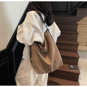 Detail view of large dark brown canvas tote bag on model for casual daily use