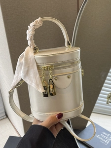 Vintage cream cylinder bucket bag with pleated handle, silk scarf, and gold hardware detail
