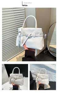 Detailed view of white lychee texture leather bag with metal buckle and cylindrical handle