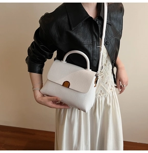 Détail du sac à main en cuir blanc à texture litchi avec fermoir métallique doré chic