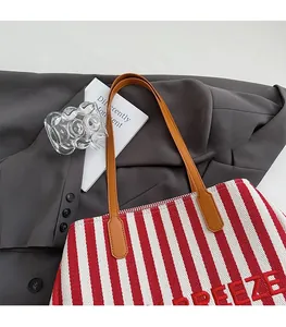 Détail du sac cabas en toile rayé rouge et blanc avec lettrage FREEZE brodé dessus