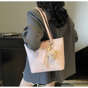 Pale pink large capacity tote bag shown on model with a cute plush bear charm