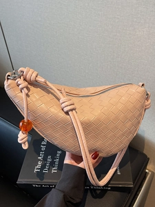 Pink woven leather crescent shoulder bag with knotted strap and decorative orange bead