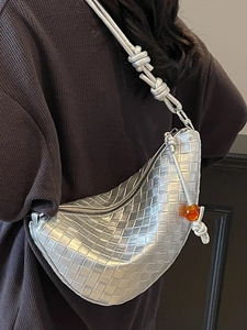 Chic metallic silver woven hobo bag with knotted strap and amber bead detail worn by model