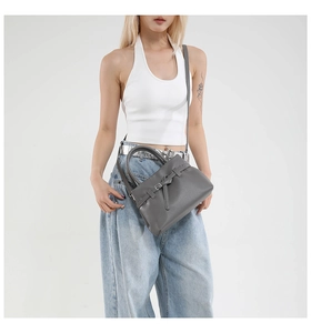 Grey litchi grain leather mini square bag with crossbody strap on a model