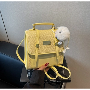 Dettaglio del mini zaino giallo con motivo a rombi e ciondolo a forma di peluche
