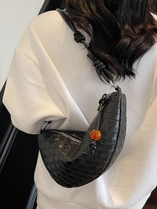 Chic black woven hobo bag with unique orange bead detail shown on model shoulder