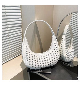 Detailansicht der weißen Hobo-Tasche mit silbernen Metallnieten in Spiegelreflexion