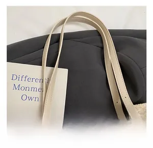 Detail of adjustable beige leather handle on a woven straw tote bag for summer