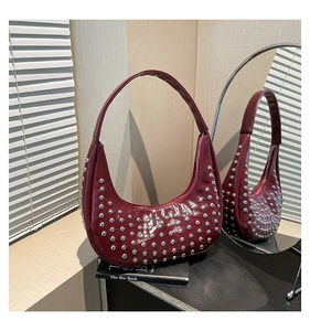 Detailansicht der dunkelroten Punk-Hobo-Tasche mit silbernen Metallnieten auf glänzendem Leder