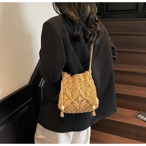Detailed close-up of woven bucket bag with bohemian tassels and decorative wooden beads