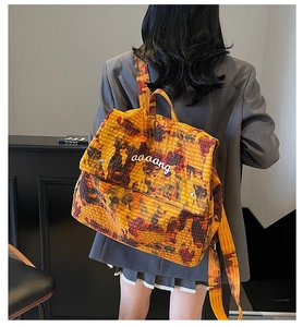 Detail of water-dye camouflage backpack with white embroidery logo on adjustable flap