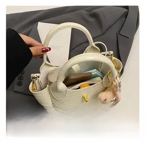 Detailansicht der geräumigen weißen Eimertasche mit Krokodilmuster und goldener Hardware