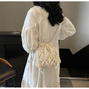 Detail of hand-woven macrame bucket bag with hollow diamond patterns and fringe knots