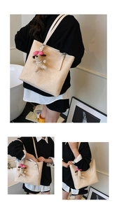 Detail of handwoven straw tote with premium white leather straps and cute puppy charm