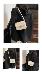 Detail of minimalist cream square crossbody bag with silver metal buckle and smooth faux leather