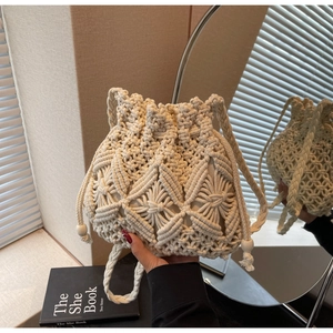 Detail showing handwoven beige bucket bag with diamond mesh patterns and drawstring beads