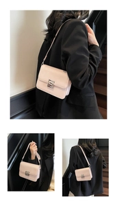 Detail of a pink square crossbody bag featuring a silver geometric metal clasp and leather texture
