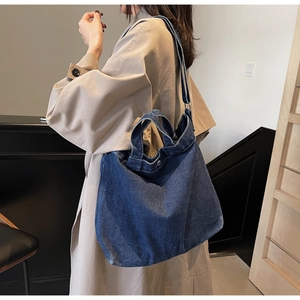 Dettaglio borsa tote in denim blu scuro con tracolla regolabile e design vintage retrò