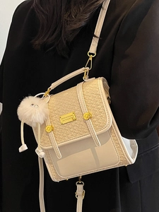 Borsa a tracolla beige con trama intrecciata, manico superiore e ciondolo a pompon morbido