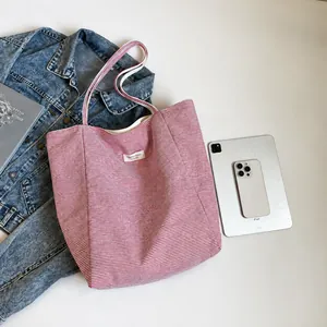 Plano de bolso tote de lona a rayas rojas con accesorios de moda y una tableta