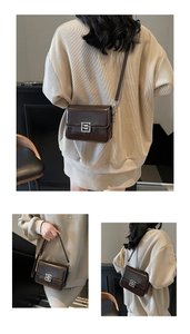 Close-up of vintage brown leather crossbody bag featuring polished silver square metal buckle