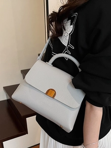 Elegant light blue litchi pattern leather handbag with golden lock and top handle strap