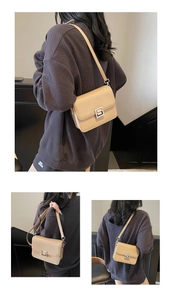 Detail view of apricot crossbody square bag with silver metal lock on a stair background