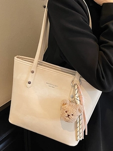 Large cream faux leather tote bag for women with plush bear charm and woven ribbon
