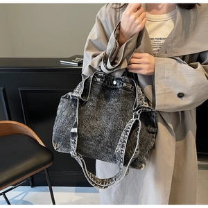 Dettaglio della borsa tote in denim lavato con consistenza spessa e doppi spallacci