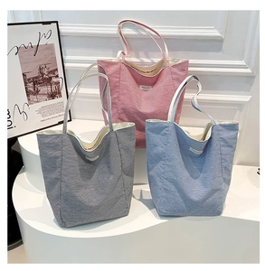 Trois sacs cabas en toile rayée rouge, noir et bleu avec broderie intérieure détaillée