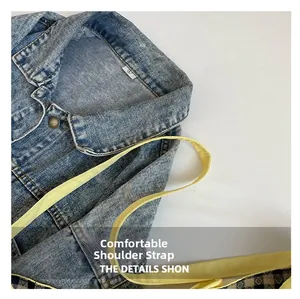Detail view of denim tote bag with checkered lining and a long yellow shoulder strap