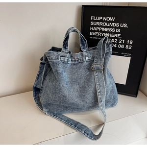 Dettaglio della borsa tote in denim azzurro con tracolla regolabile e fibbia in metallo